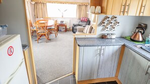Een compacte leefruimte met een kitchenette, een eethoek en een gezellige zithoek met uitzicht.