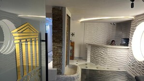 Un espace d’accueil au design moderne, comprenant un comptoir de réception et un espace salon.