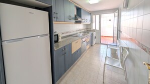 Eine Küche mit Schränken, einem Kühlschrank, einer Mikrowelle und einem Spülbecken.