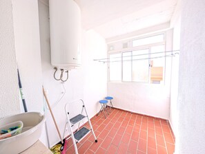A room with a white heater, a step ladder, a bucket, and a broom. - 139 Livingtarifa Gonga House (Tarifa)