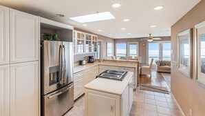 Una cocina moderna con horno empotrado, refrigerador y una isla central con estufa.