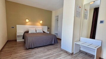Una camera da letto con un letto, comodini, uno specchio e un armadio.