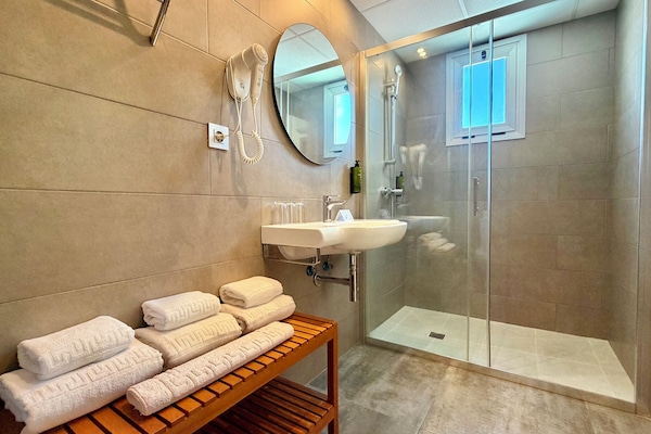 Driepersoonskamer, balkon | Badkamer | Een douche, een haardroger, handdoeken