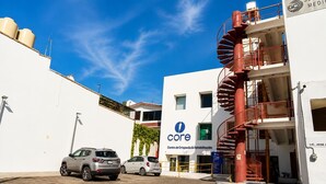 Ein Gebäude mit einem 'core'-Schild, einer Wendeltreppe und parkenden Autos.