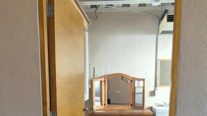 Ein Zimmer mit einem Holztisch, einer Bank und einem Kleiderschrank.