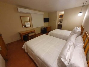 Camera d'albergo con due letti, una scrivania, una sedia, un televisore e un condizionatore d'aria.