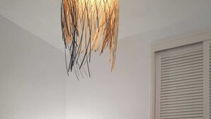 Een slaapkamer met een bed, nachtkastje, lamp en kledingkast.