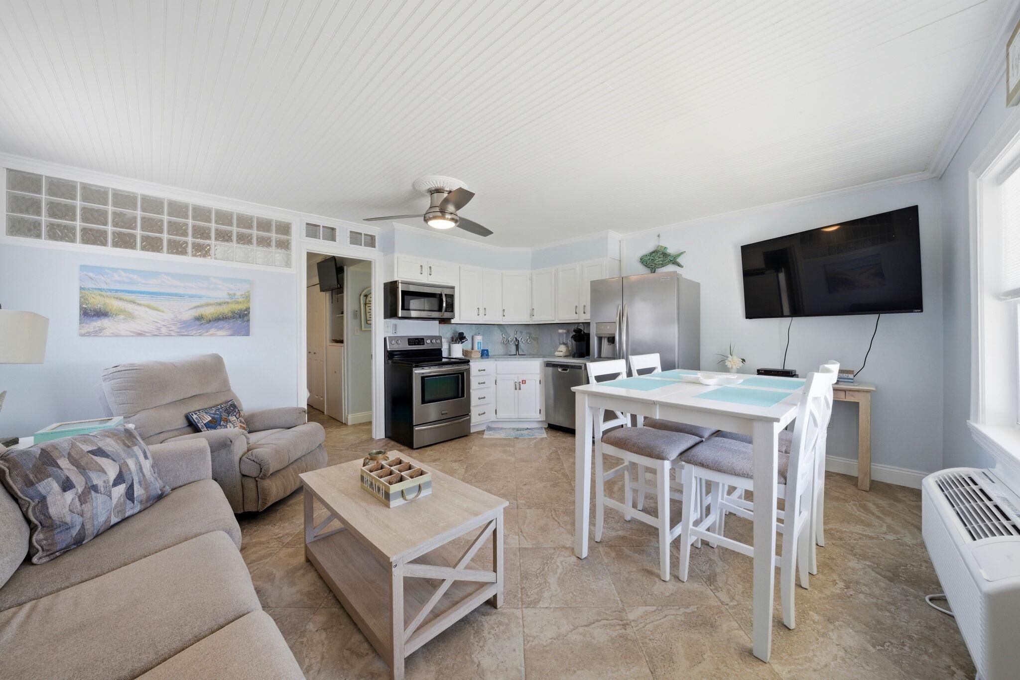 A modern living room with a sofa, coffee table, and dining area.