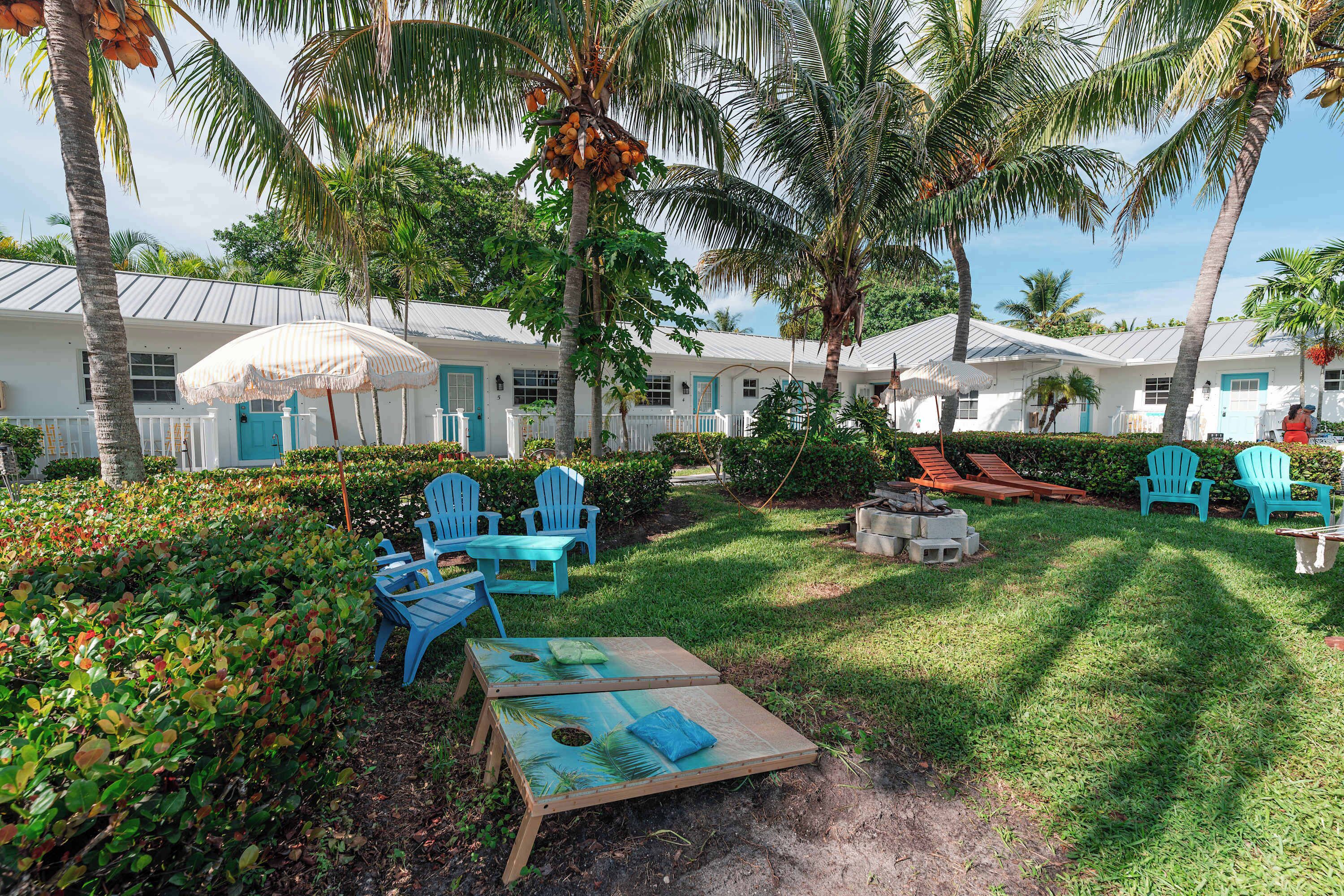 Un resort con mobiliario exterior, palmeras y una zona de piscina.