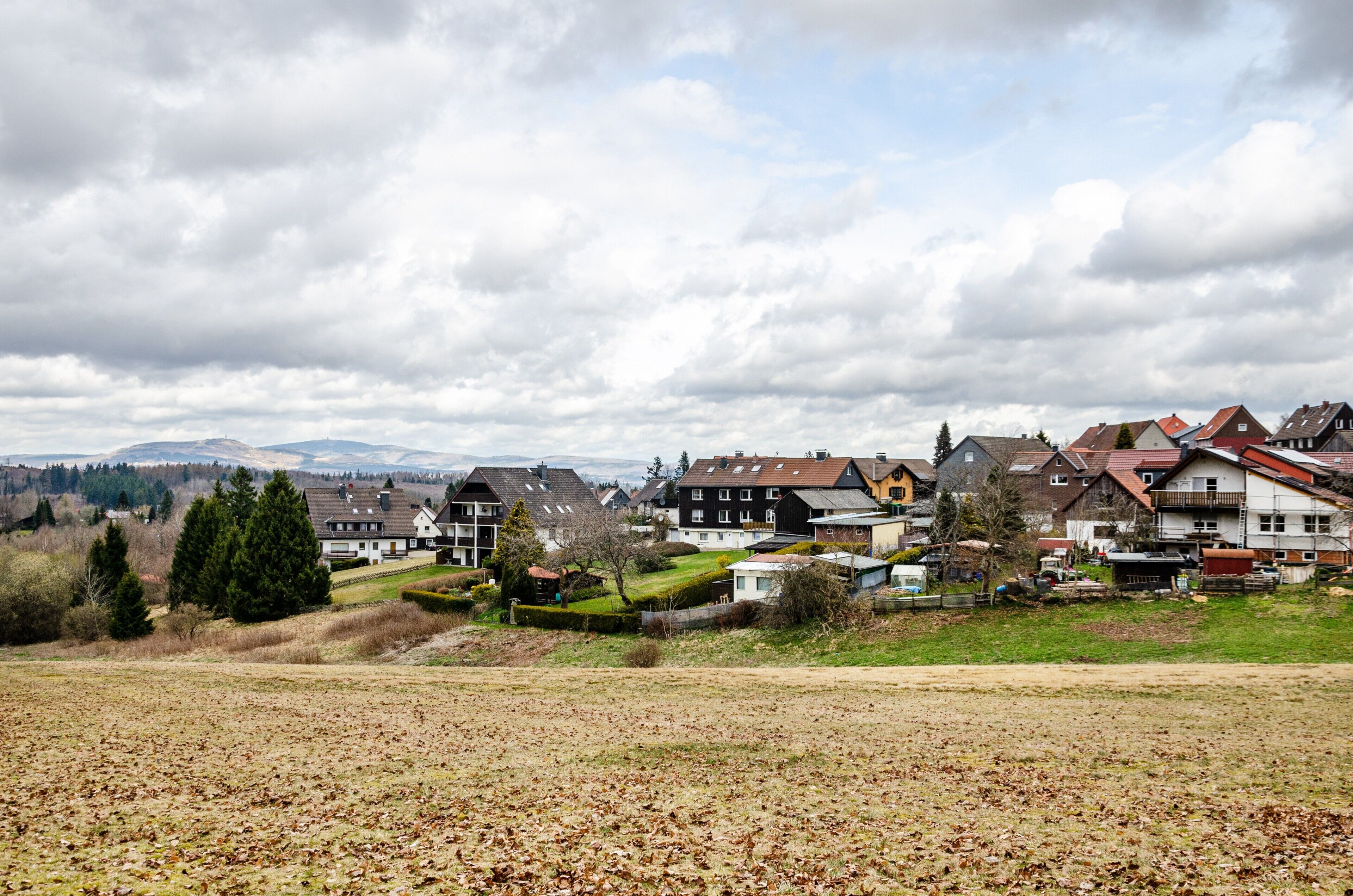 Zona residencial con casas, un campo y cielo nublado.