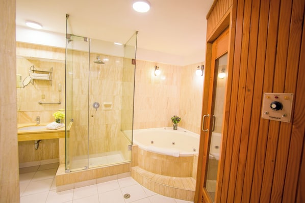 A modern bathroom with a glass-enclosed shower, a wooden vanity, and a freestanding bathtub. - Britania San Borja (Lima)