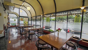 A restaurant with a curved roof, large windows, and a view of a body of water. - Britania San Borja (Lima)