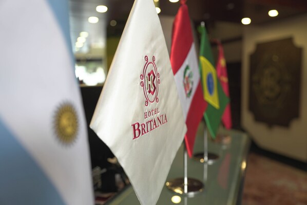 Flags of Argentina, Brazil, and the United Kingdom displayed in a hotel lobby.