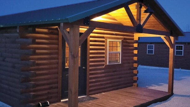 A log cabin with a wooden porch and a window. - Beautiful 1-bedroom Cabin #5 with AC overlooking swim pond (Rayville)