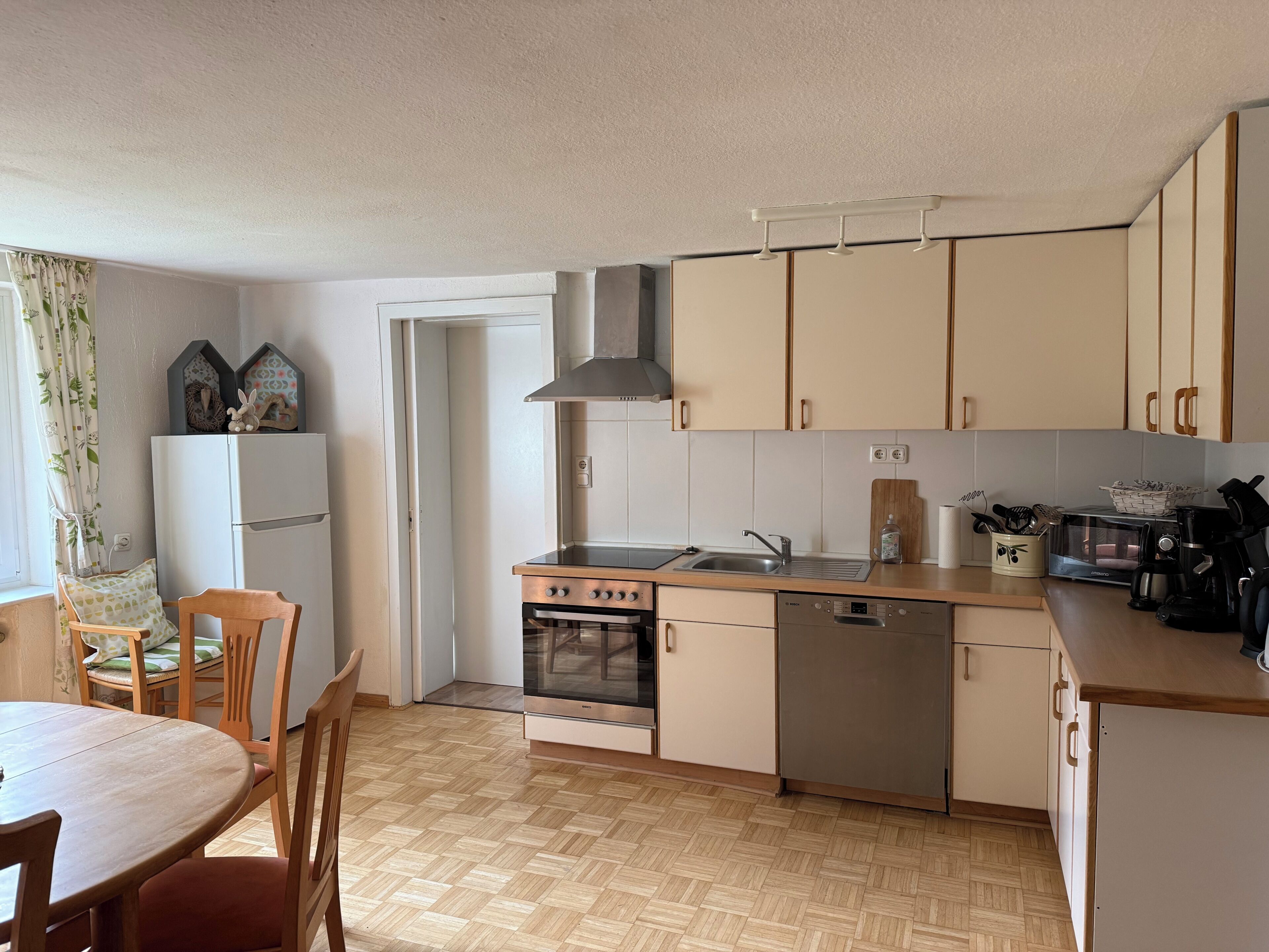 A kitchen with a stove, oven, sink, and cabinets.