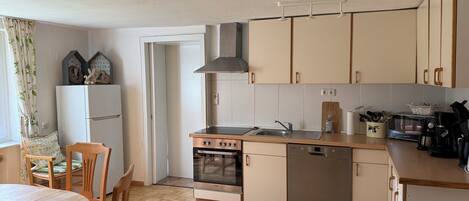 A kitchen with a stove, oven, sink, and cabinets.