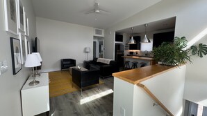 En moderne lejlighed med opholdsstue, køkken og spiseplads.