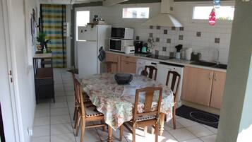 Cocina compacta con zona de comedor, que incluye microondas, tostadora, pileta y armarios de madera.