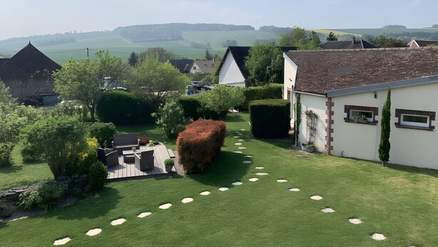 A residential area with a well-maintained lawn, a pathway, and a white building with a tiled roof. - Guesthouse at the Rooster's Song (Saint-Lyé)