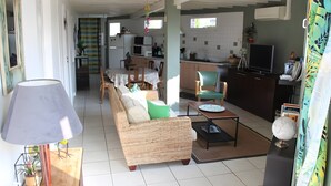 A living room with a sofa, a coffee table, a lamp, and a television. - Guesthouse at the Rooster's Song (Saint-Lyé)
