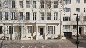 A row of townhouses with a front porch, a bicycle lane, and a street lamp. - Hyde Park Studio Flat by Keyhol Stays (London)