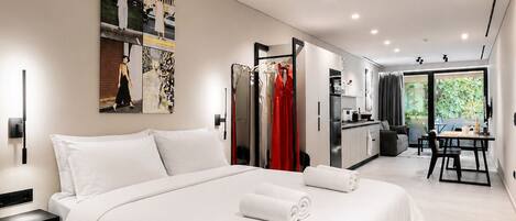 Een moderne hotelkamer met een groot bed, een zithoek en uitzicht op het landschap.