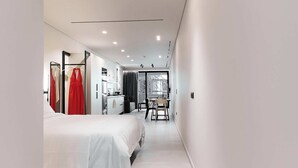A modern hotel room with a bed, a desk, and a chair. - Moid Urban Suites (Athens)