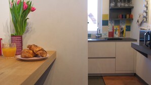 A kitchen with a countertop, a vase with flowers, and a plate with croissants. - Casa Zeda WelcHome (Intra)