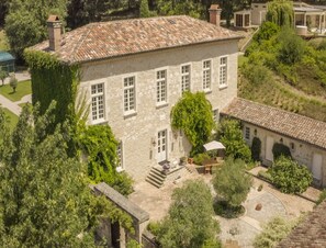 A stone building with a tiled roof, surrounded by greenery and a small courtyard. - French Estate With Pool & Sauna (Damiatte)