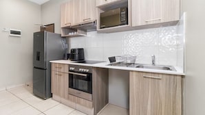 Een moderne keuken met een koelkast, oven, magnetron en spoelbak.