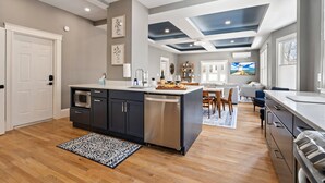 A modern kitchen with a central island, built-in appliances, and a dining area with a view. - Maine Social House/By Downtown/Balcony (Portland)