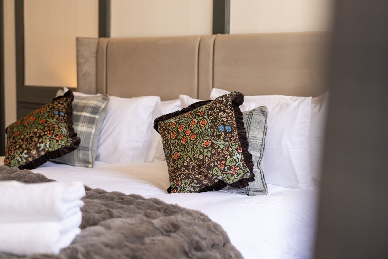 A bed with multiple pillows, a headboard, and a blanket.