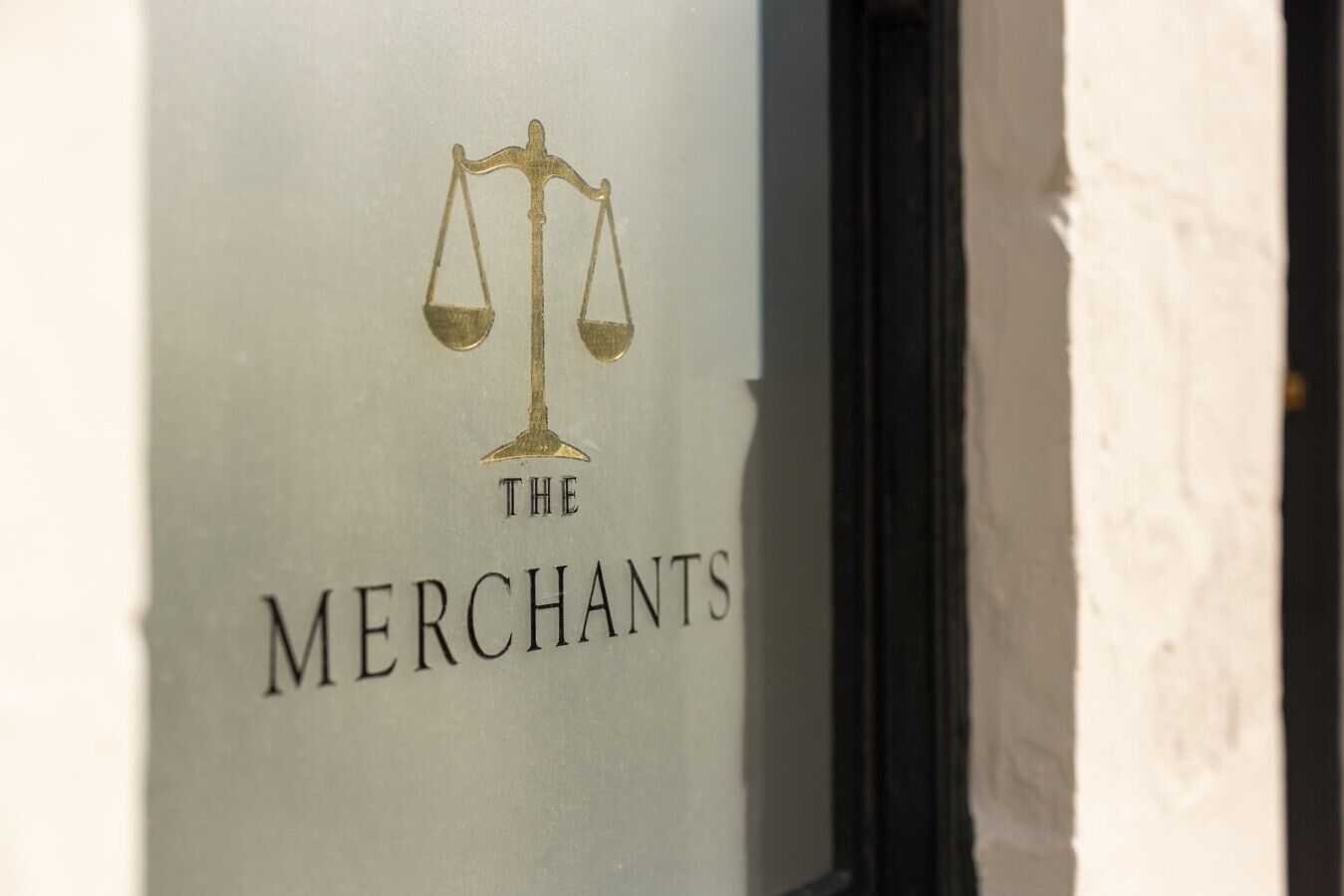 Un logotipo con escamas y el texto 'THE MERCHANTS' en una pared.