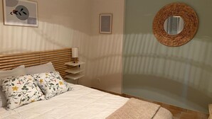 A bedroom with a bed, a bedside table with a lamp, a wall-mounted mirror, and a framed picture. - Private Pool • Sillans Waterfall • Verdon • Nature Getaway in Provence (Sillans-la-Cascade)