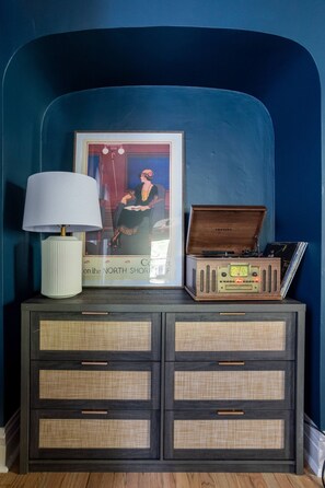 A dark wooden cabinet with woven drawers, a vintage radio, and a framed picture on top. - Jan 2027 open ! A-ville Historic Apt w/ Office (Chicago)