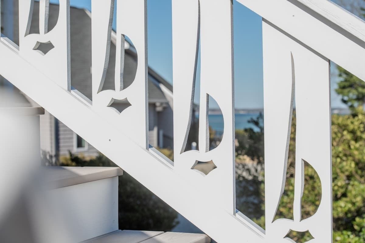 A white staircase with a railing that has cut-out letters spelling 'PARK.'