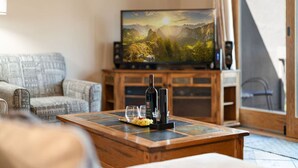 A living room with a television, a wooden coffee table, and a sofa.