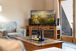 Un salon avec un téléviseur, une table basse en bois et un canapé.