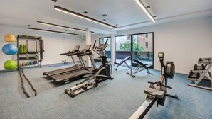 A gym with treadmills, elliptical machines, and free weights.