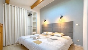Une chambre à coucher comprenant un lit, une armoire et deux lampes fixées au mur.