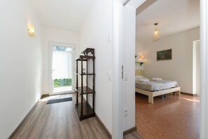 Ein Schlafzimmer mit einem Bett, einem Nachttisch, einer Lampe und einem Fenster.