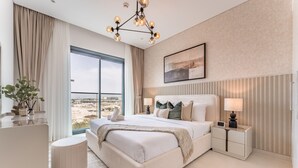 Camera da letto moderna con un letto grande, comodini, vista sulla città e un lampadario.