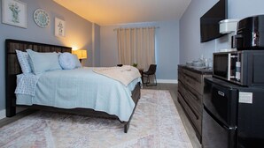 A bedroom with a bed, a dresser, a TV, and a microwave. - Modern Mins To "Atrium & Novant" Uptown Char Airport (Charlotte)