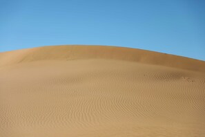 A desert landscape with sand dunes under a clear sky. - Hamada Retreat (Tisserdmine)
