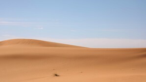 A desert landscape with sand dunes under a clear sky. - Hamada Retreat (Tisserdmine)
