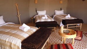 A hotel room with two beds, a small round table with a basket, and a wooden chair. - Hamada Retreat (Tisserdmine)