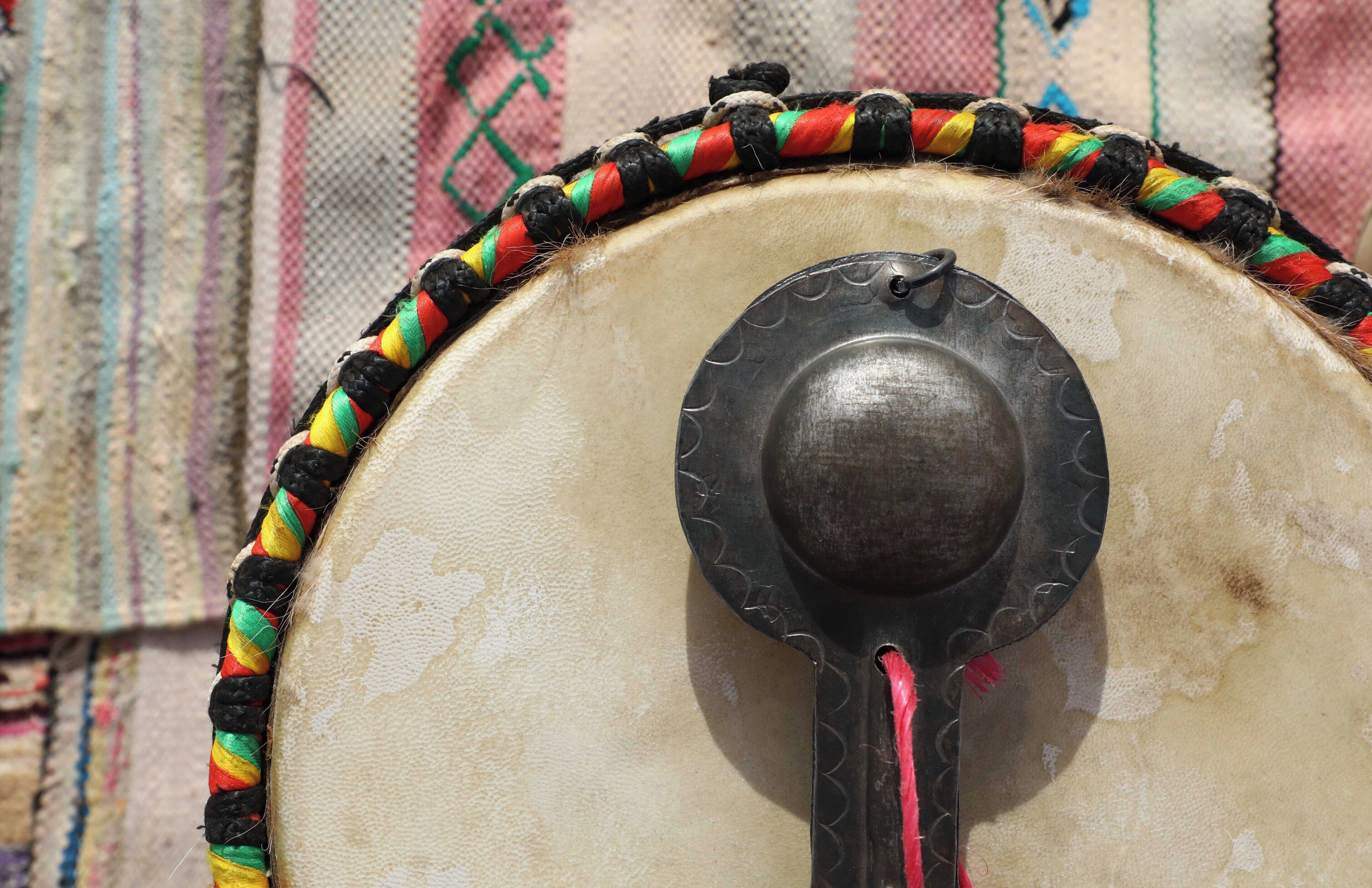 A drum with a decorative rope and a metal handle.