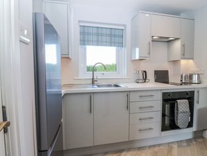 A modern kitchen with a stainless steel refrigerator, a built-in oven, a coffee maker, and a toaster. - Little Norwood (Perth)