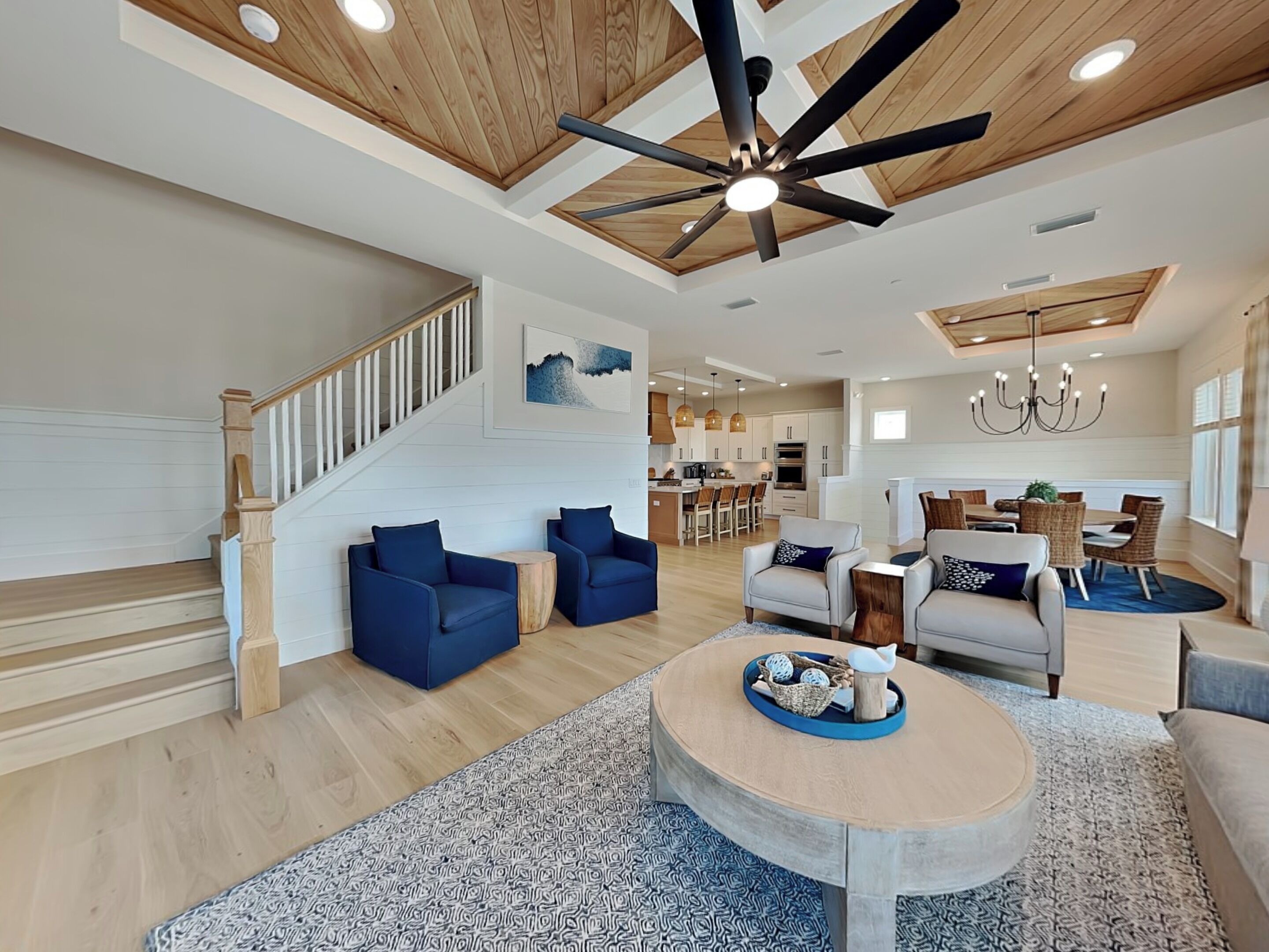 A spacious living area with a high ceiling, a dining area, and a kitchen.