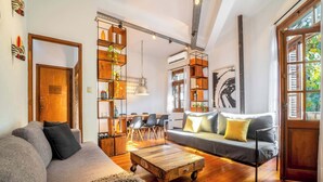 A cozy living room with a sofa, a coffee table, and a bookshelf. - MOT Rentals + Dorrego House - Pool in Palermo Hollywood (Buenos Aires)
